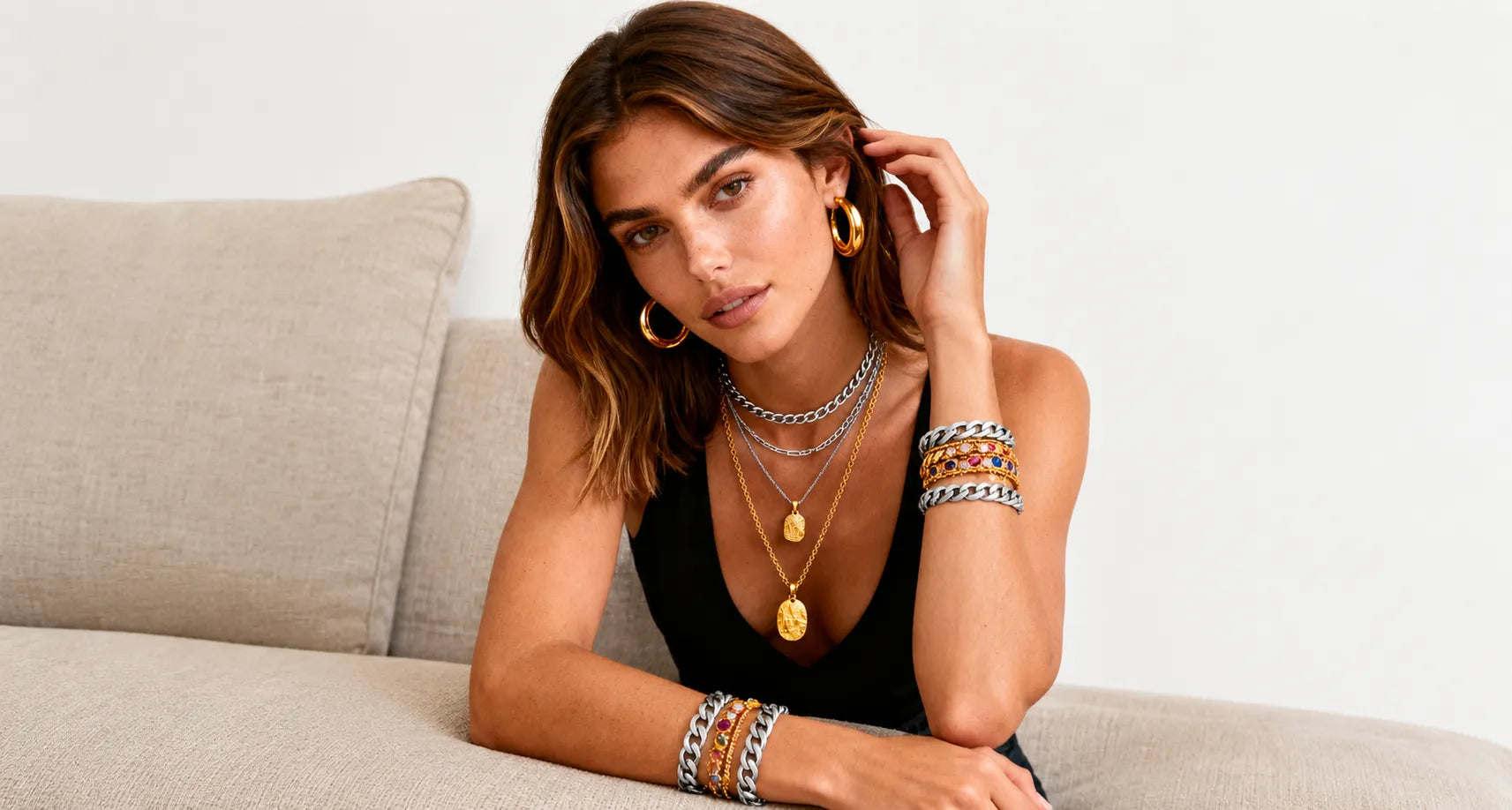 Model showcasing wholesale gold jewelry with hoop earrings, layered necklaces and bracelets for jewelry boutiques and fashion retailers.