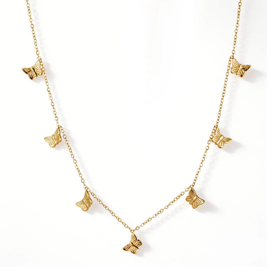 Gold necklace featuring multiple textured butterfly charms spaced along a fine chain, shown on a white background.