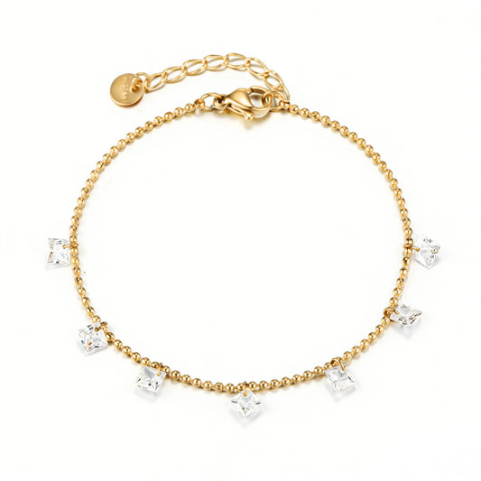 Gold bracelet featuring a row of dangling clear accents on a gold-tone chain, shown on a white background.