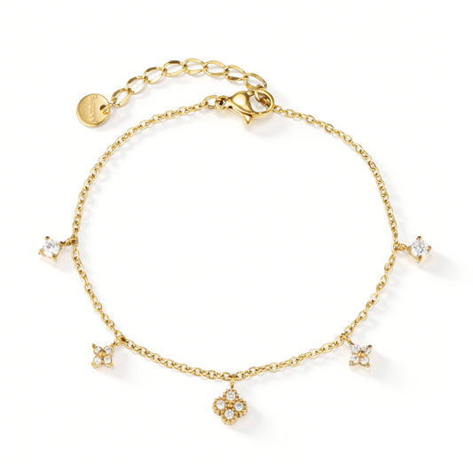 Gold bracelet featuring dangling flower-shaped accents with clear details, shown on a white background.