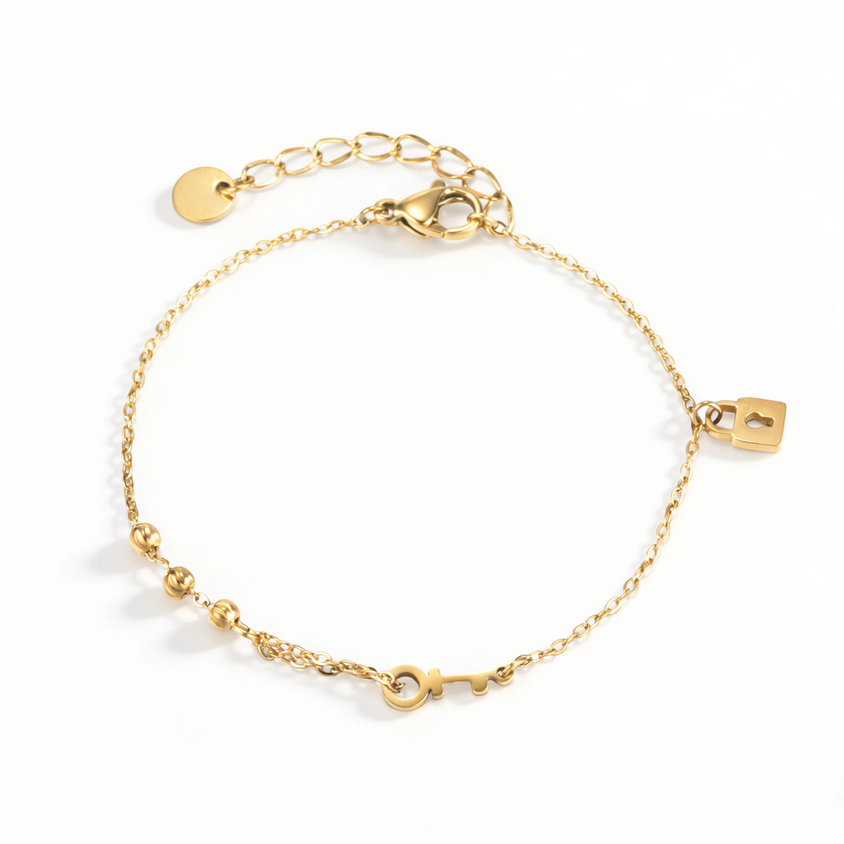 Gold bracelet featuring a padlock charm, key detail and small round beads, shown on a white background.