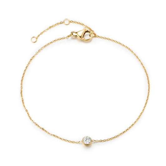 Gold bracelet featuring a fine gold-tone chain and a single clear round accent, shown on a white background.