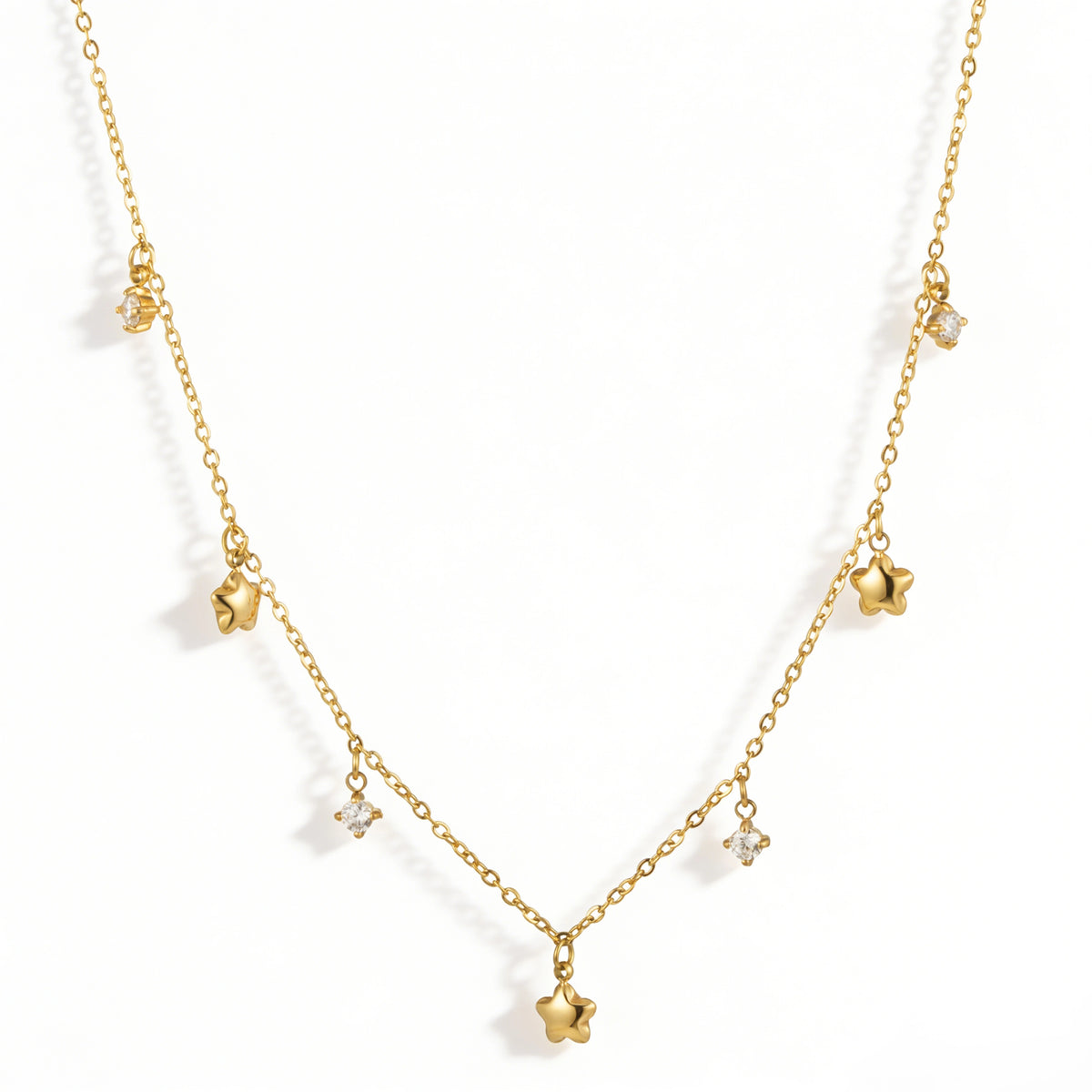 Gold necklace featuring gold-tone star charms alternating with small white accents, shown on a white background.